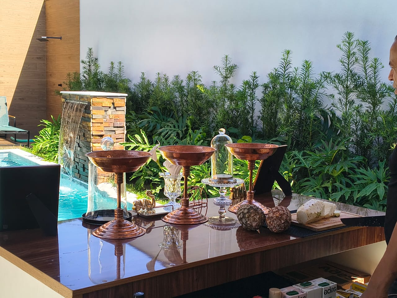 Bar de aniversário com bowls de cobre e frutas à beira da piscina
