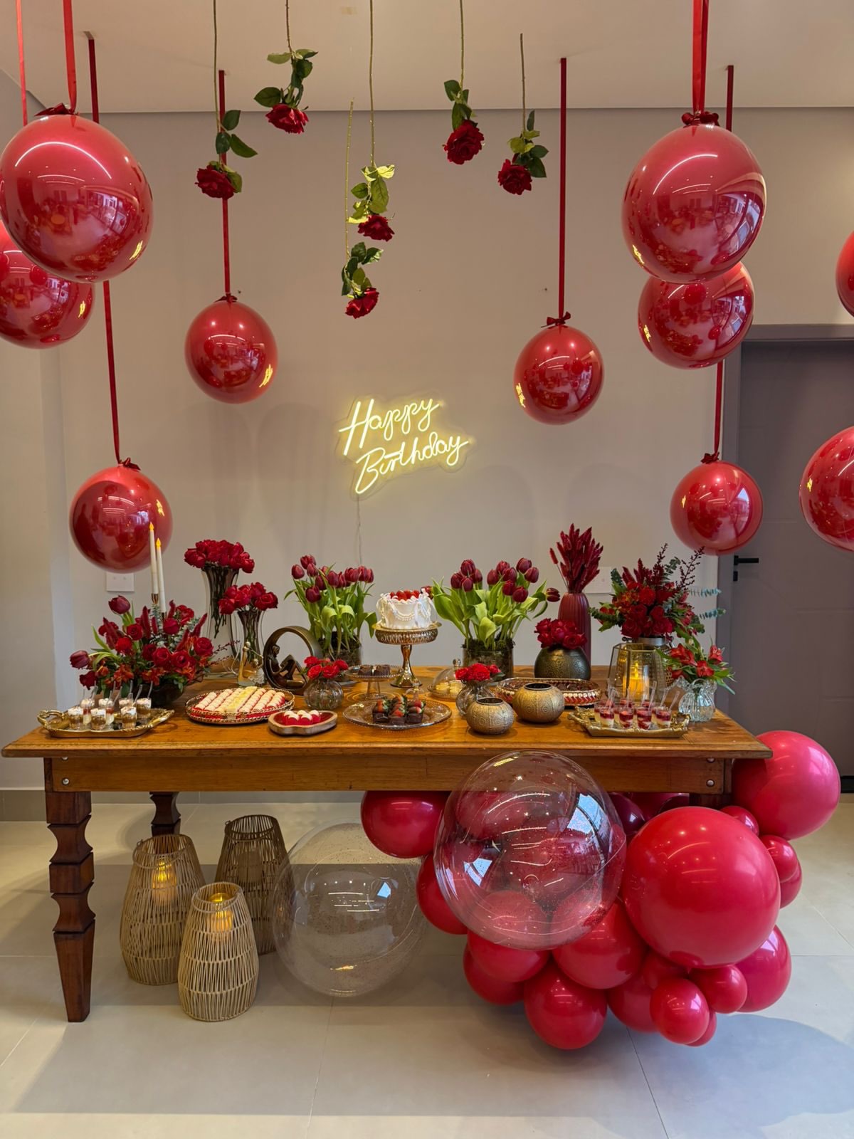 Mesa de aniversário com balões vermelhos, rosas e neon Happy Birthday