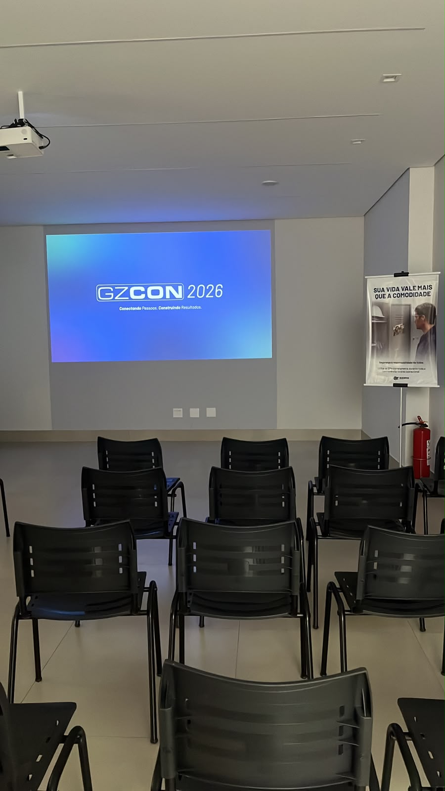 Auditório com projetor e cadeiras montado para convenção empresarial