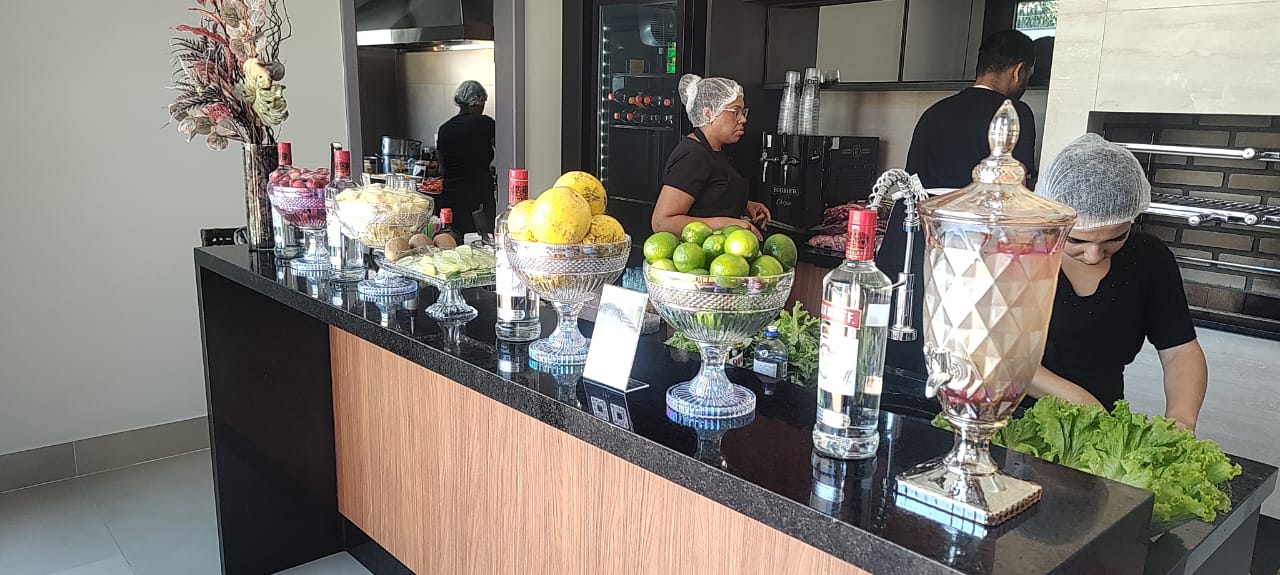 Balcão do bar com frutas frescas e bebidas sendo preparadas